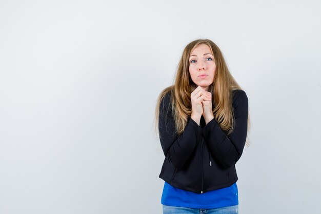 Ausdrucksstarke junge Frau, die im Studio aufwirft