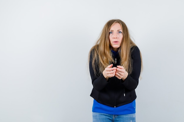 Ausdrucksstarke junge Frau, die im Studio aufwirft