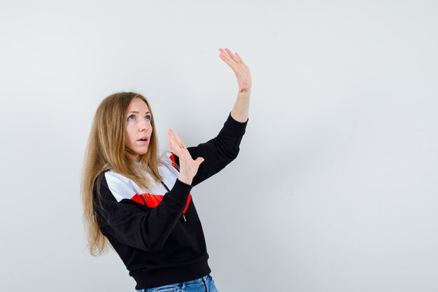 Ausdrucksstarke junge Frau, die im Studio aufwirft