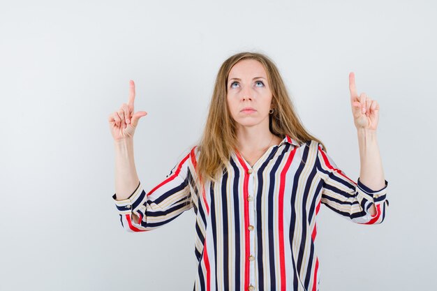 Ausdrucksstarke junge Frau, die im Studio aufwirft