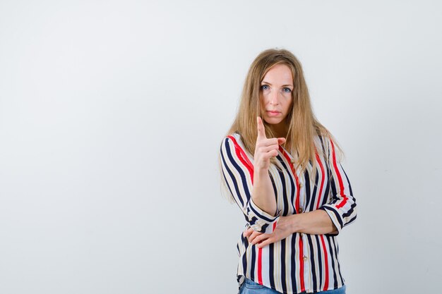 Ausdrucksstarke junge Frau, die im Studio aufwirft