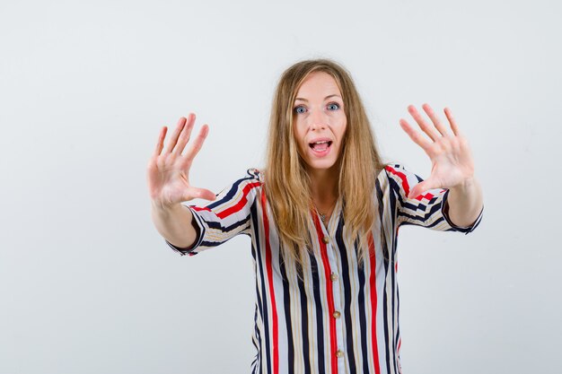 Ausdrucksstarke junge Frau, die im Studio aufwirft