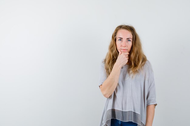 Ausdrucksstarke junge Frau, die im Studio aufwirft