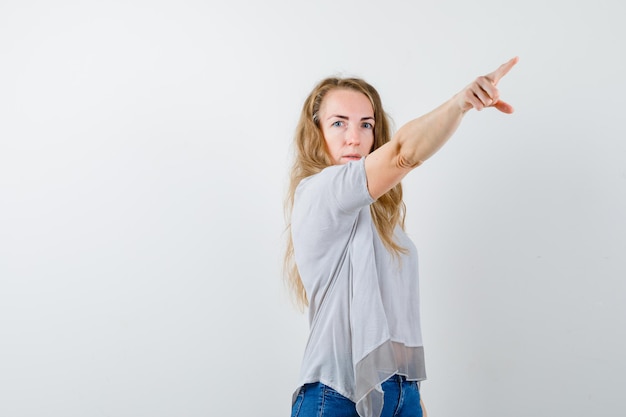 Ausdrucksstarke junge Frau, die im Studio aufwirft