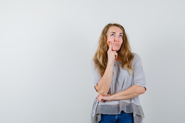 Ausdrucksstarke junge Frau, die im Studio aufwirft