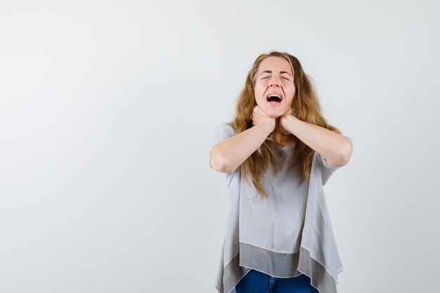 Ausdrucksstarke junge Frau, die im Studio aufwirft