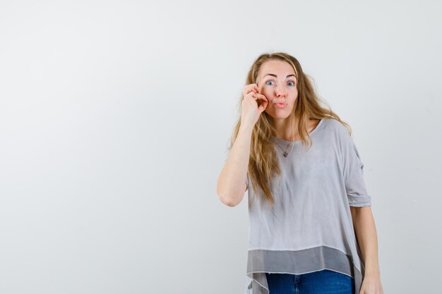 Ausdrucksstarke junge Frau, die im Studio aufwirft