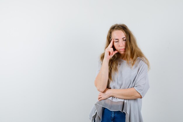 Ausdrucksstarke junge Frau, die im Studio aufwirft