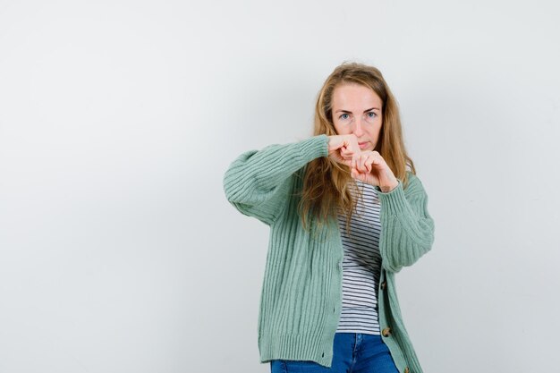 Ausdrucksstarke junge Frau, die im Studio aufwirft