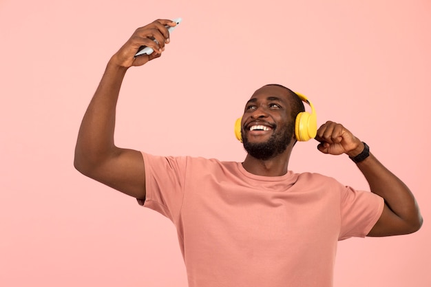 Kostenloses Foto ausdrucksstarker afroamerikaner, der musik über kopfhörer hört