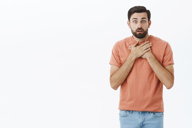 Ausdrucksstarker bärtiger Mann im orangefarbenen T-Shirt