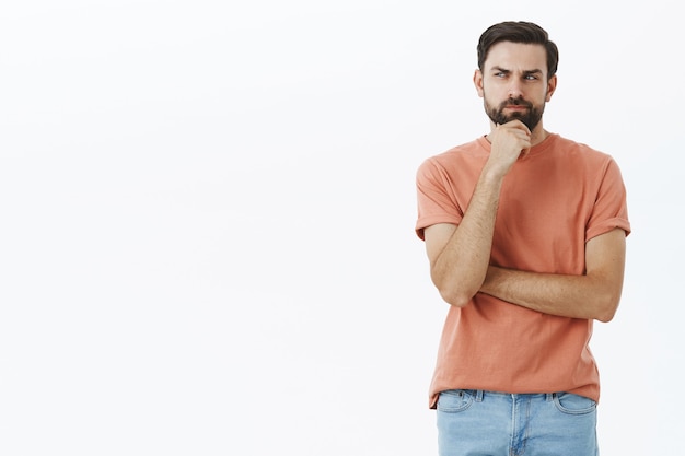 Ausdrucksstarker bärtiger Mann im orangefarbenen T-Shirt