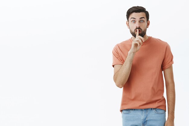 Ausdrucksstarker bärtiger Mann im orangefarbenen T-Shirt