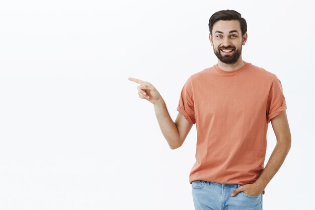 Ausdrucksstarker bärtiger Mann im orangefarbenen T-Shirt