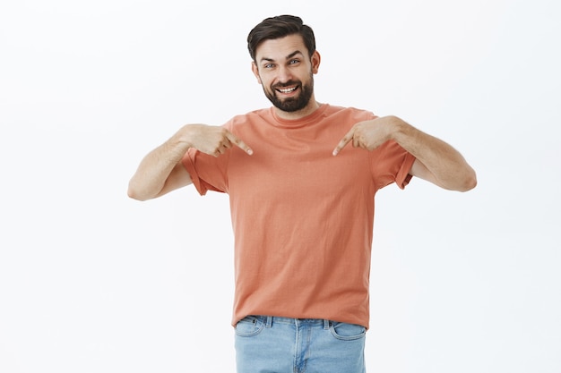 Ausdrucksstarker bärtiger Mann im orangefarbenen T-Shirt