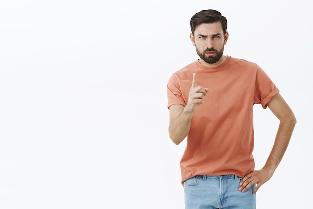 Ausdrucksstarker bärtiger Mann im orangefarbenen T-Shirt