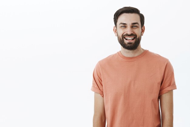 Ausdrucksstarker bärtiger Mann im orangefarbenen T-Shirt