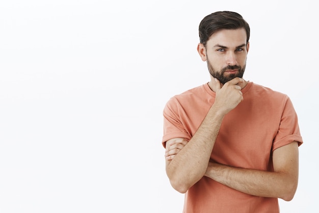 Ausdrucksstarker bärtiger Mann im orangefarbenen T-Shirt