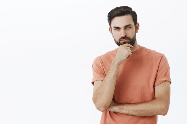 Ausdrucksstarker bärtiger Mann im orangefarbenen T-Shirt