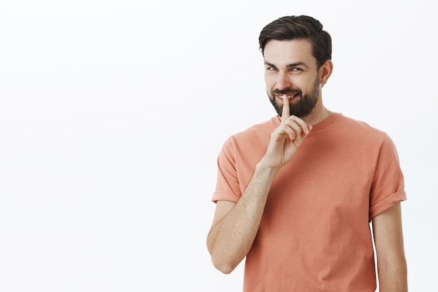 Ausdrucksstarker bärtiger Mann im orangefarbenen T-Shirt