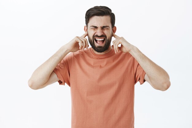 Ausdrucksstarker bärtiger Mann im orangefarbenen T-Shirt