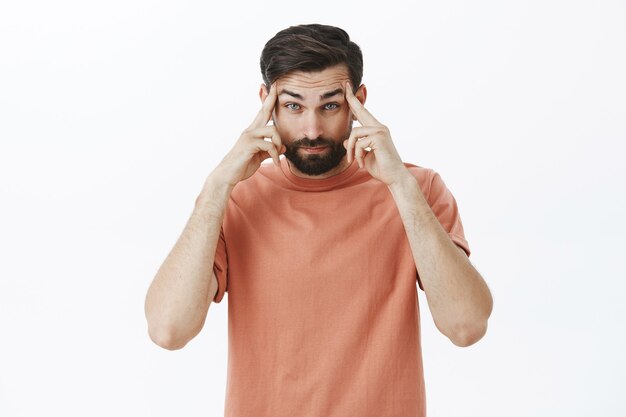 Ausdrucksstarker bärtiger Mann im orangefarbenen T-Shirt