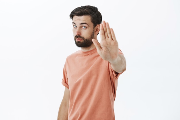 Kostenloses Foto ausdrucksstarker bärtiger mann im orangefarbenen t-shirt