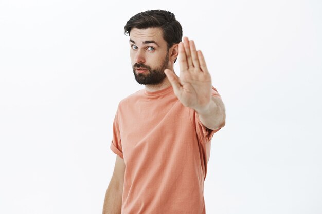 Ausdrucksstarker bärtiger Mann im orangefarbenen T-Shirt