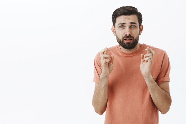 Ausdrucksstarker bärtiger Mann im orangefarbenen T-Shirt