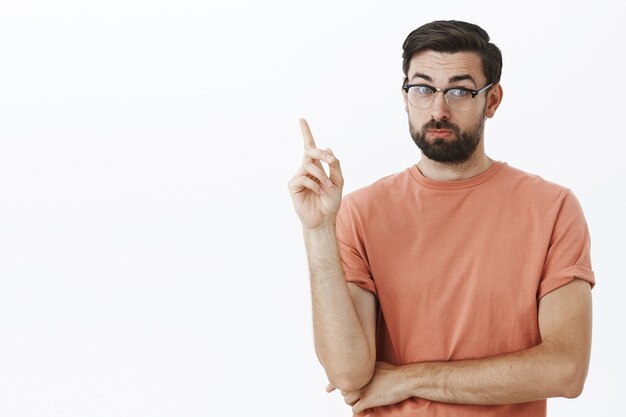 Ausdrucksstarker bärtiger Mann im orangefarbenen T-Shirt