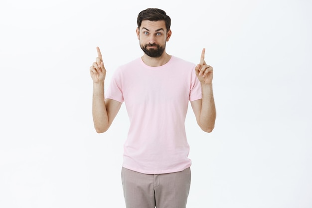 Ausdrucksstarker bärtiger Mann im rosa T-Shirt