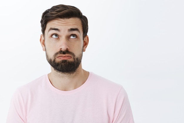 Ausdrucksstarker bärtiger Mann im rosa T-Shirt