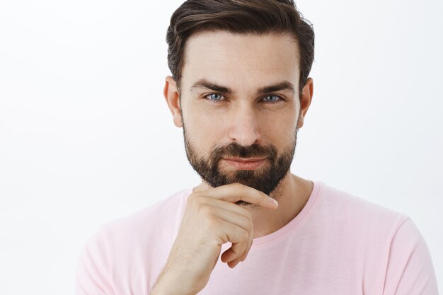 Ausdrucksstarker bärtiger Mann im rosa T-Shirt