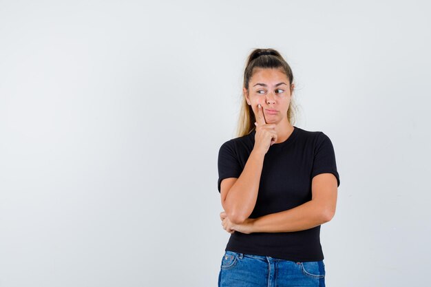 Ausdrucksstarkes junges Mädchen, das im Studio aufwirft