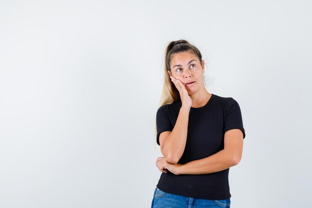 Ausdrucksstarkes junges Mädchen, das im Studio aufwirft