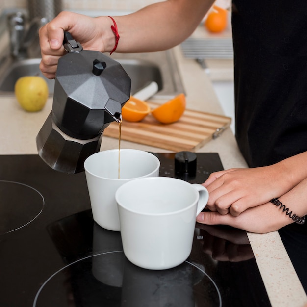 Auslaufender Kaffee der lesbischen Frau in der Küche