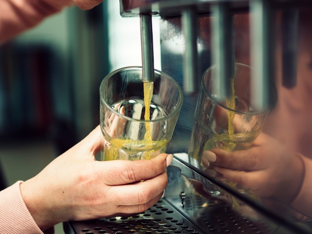 Auslaufendes Getränk der Erntefrau Hand im Glas