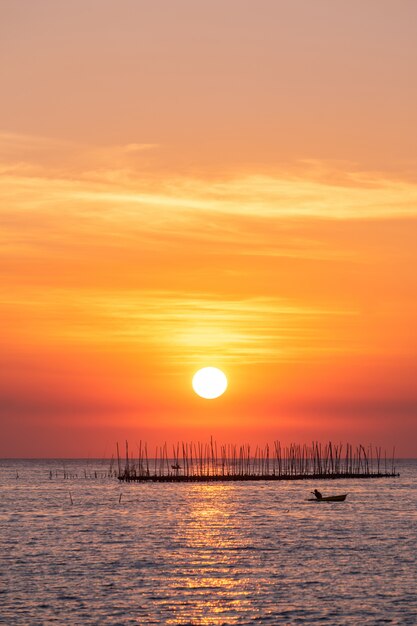 Austernbauernhof im Sonnenunterganghintergrund des Meeres und des schönen Himmels