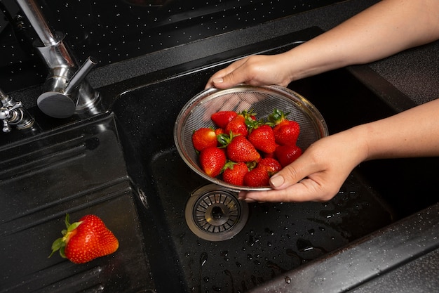 Auswahl an erdbeeren, die gewaschen werden