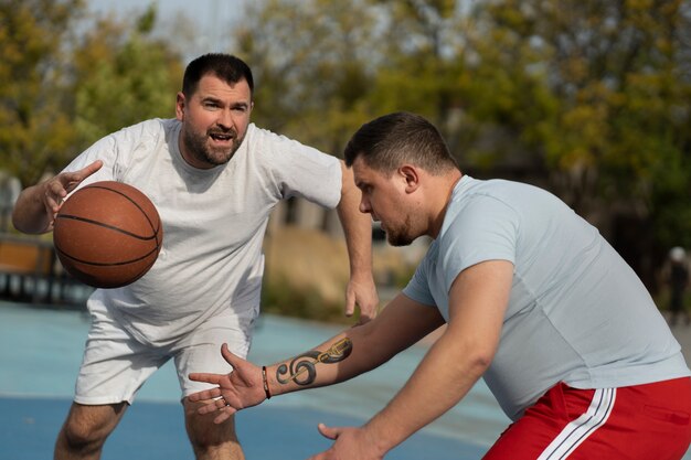 Authentische Szenen von übergroßen Männern, die Basketball spielen