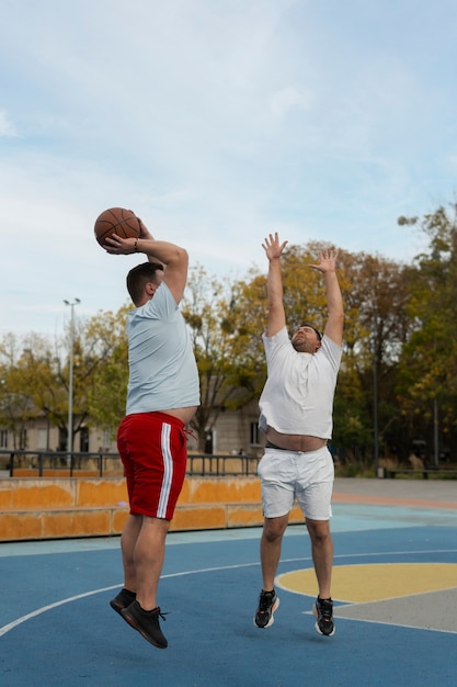 Authentische Szenen von übergroßen Männern, die Basketball spielen