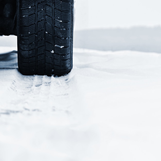 Kostenloses Foto auto im winter. reifen auf einer verschneiten straße bei schlechtem wetter.
