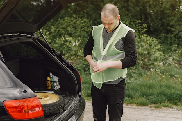 Auto mit Problemen und einem roten Dreieck, um andere Verkehrsteilnehmer zu warnen