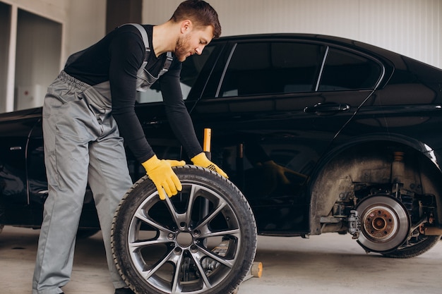 Automechaniker beim Radwechsel im Auto