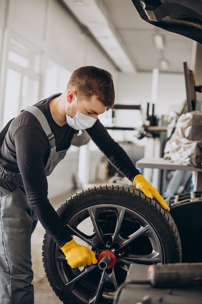 Automechaniker beim Radwechsel im Auto