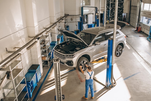 Automechaniker, der Auto überprüft