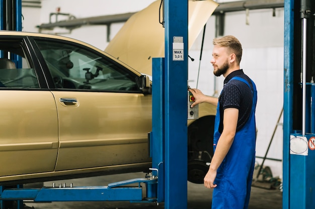 Automechaniker, der Druckknopf bedrängt