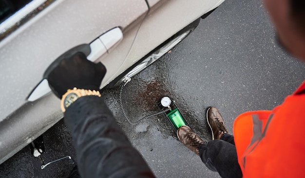 Kostenloses Foto automechaniker, der reifen mit luftkompressor auf der straße aufpumpt