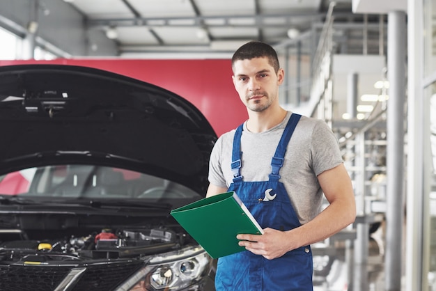 Automechaniker Mann oder Schmied mit Zwischenablage in der Werkstatt.