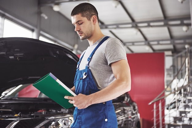 Automechaniker Mann oder Schmied mit Zwischenablage in der Werkstatt.